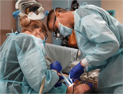Dr. Eric is doing dental work with his female colleague.